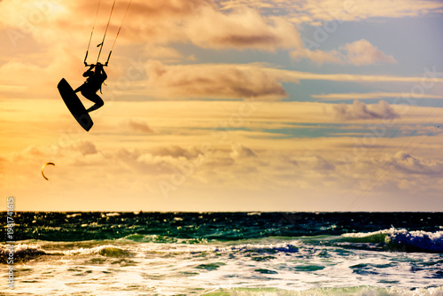 Kite surfer riding waves. Kiteboarding sport.