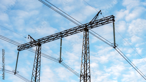 High-voltage power lines stretch across a clear blue sky