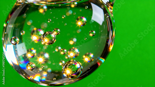 Artistic macro shot of a clear liquid serum droplet containing suspended glowing molecules and active ingredients isolated on a solid bright chroma key green screen background for skincare