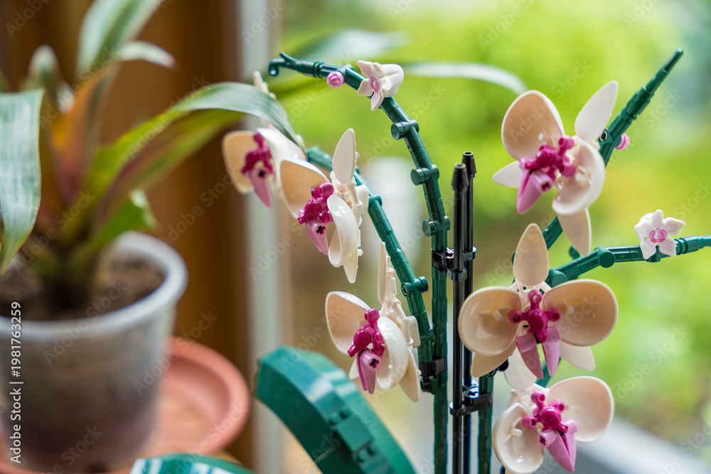 Fototapeta premium Prague, Czech republic - May 8, 2024: A detailed view of a plastic orchid crafted from Lego bricks, presenting a stylish, long-lasting, and eco-friendly alternative to traditional home plants.