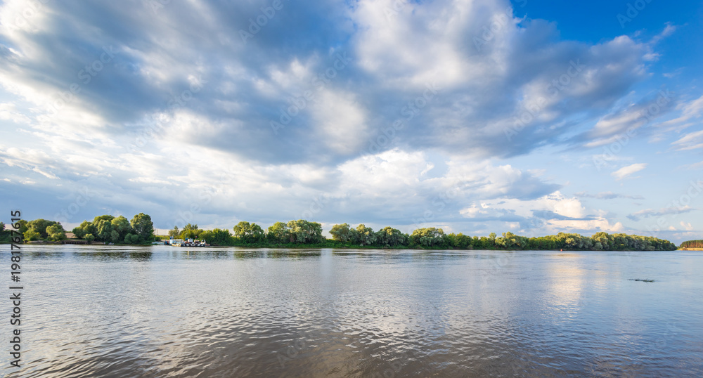 Obraz premium Blue sky holds wispy clouds above calm lake waters