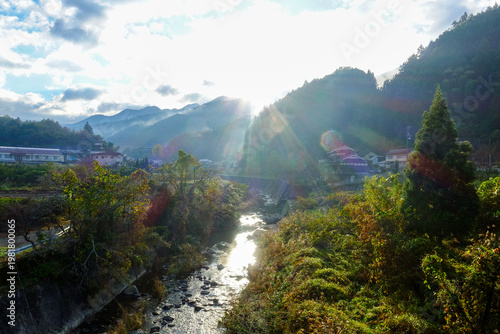 Sun rays over mountain village and river along Shikoku Henro route Japan