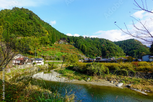 Sunny rural valley with river and traditional village along Shikoku Henro route Japan