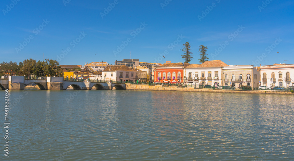 Obraz premium Colorful riverside buildings and bridge in Tavira Portugal