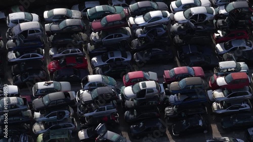 Aerial view of a tightly packed junkyard with wrecked cars of various colors, creating a textured landscape of metal and glass, Aveiro, Portugal.