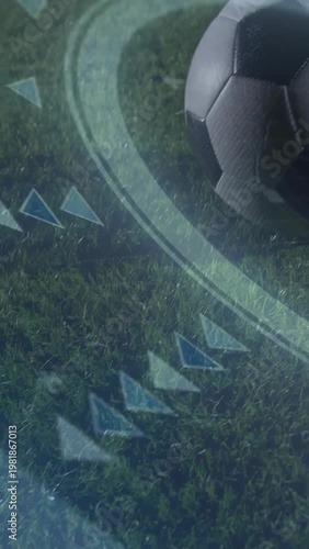 Soccer ball rolling across grass with broadcast graphics and boot blur on right, copy space