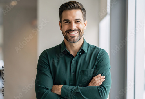 Confident Professional Male Entrepreneur in Emerald Green Shirt Standing with Arms Crossed in Modern Bright Office - Professional Corporate Headshot.