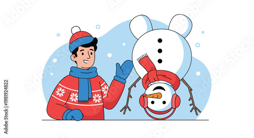 Young man in a red sweater and blue scarf stands happily next to a creative snowman built completely upside down in a snowy winter landscape.