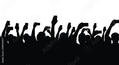 Silhouetted crowd of people holding up their smartphones recording a live event or taking photos.