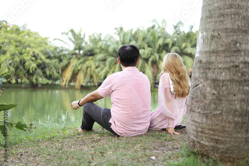 Low Angle Perspective of Asian Couple by Park Lake