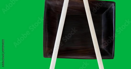 Sushi text banner with chopsticks on a plate against black background