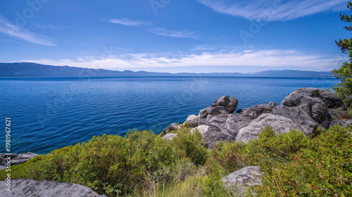 A serene landscape of a rocky coastline with lush greenery and a calm ocean