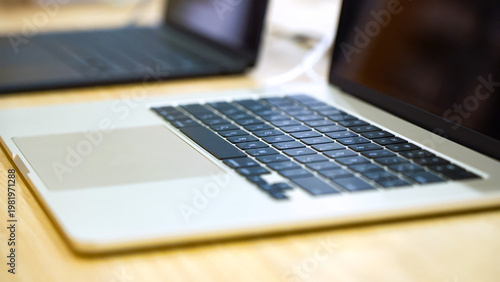 A Close-Up View of a Modern Laptop on a Wooden Desk, Highlighting the Sleek Keyboard and Touchpad Design in a Contemporary Workspace Setting