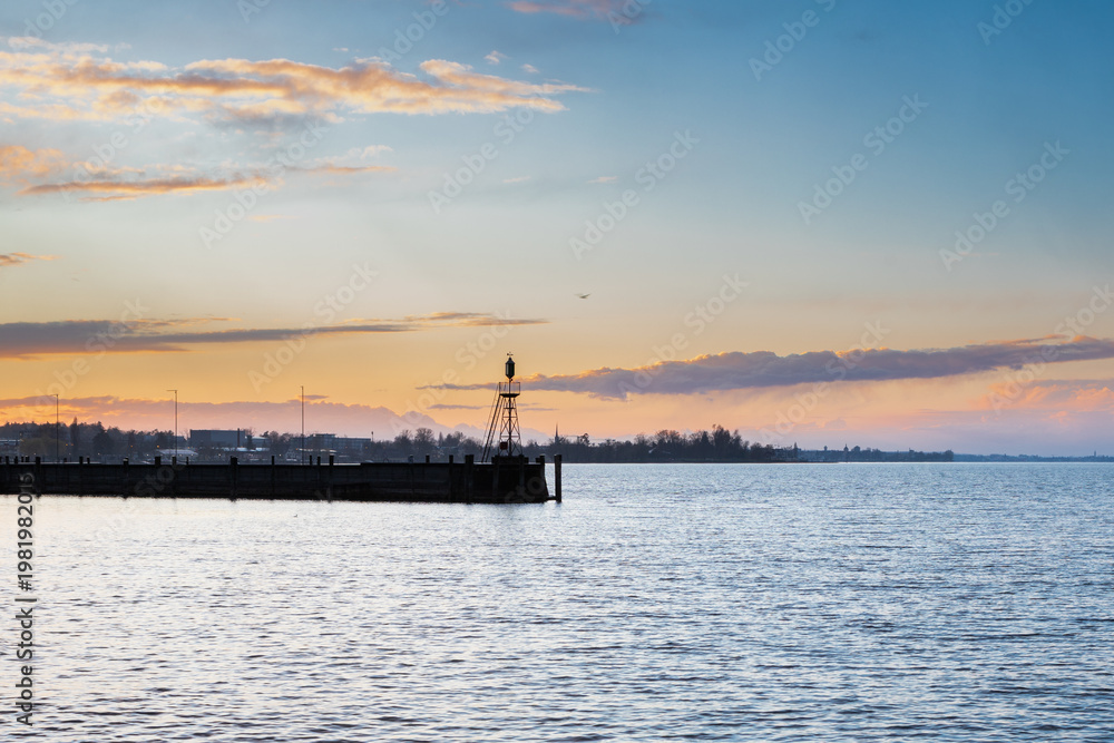 Obraz premium Amazing sunset seen from the pier of the city of Rorschach over Lake Constance in the Sankt Gallen region in Switzerland with an impressive rolling cloudscape full of unpredictable weather and snow sh