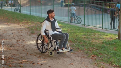 Emotionally withdrawn scene, Man in wheelchair feels solitude, Man sitting by fence displays inner emotional conflict