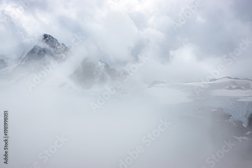 Photos Foggy mountain landscape with glacier and low visibility conditions