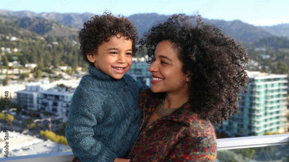 Fototapeta premium Mother and son enjoy time together in the city with mountains in view