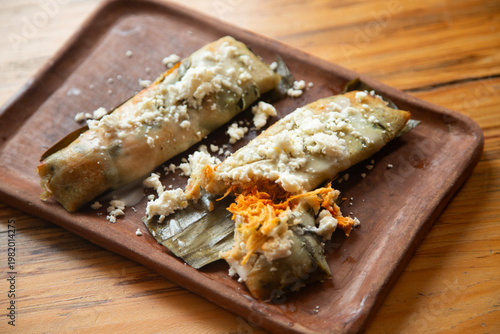Tableau sur toile Authentic Chiapas tamales served on a rustic clay plate with crumbled cheese and filled with meat