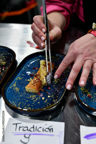 chef emplatando postre con flores comestibles utilizando una pinza de cocina