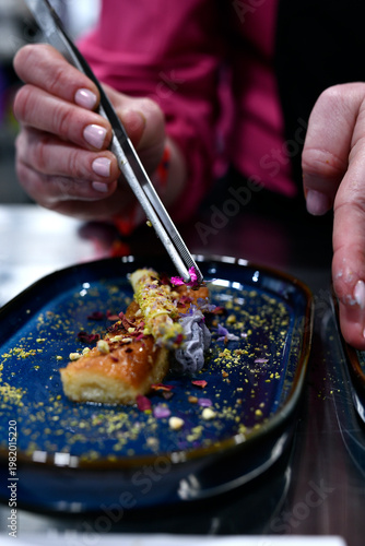 Experto repostero emplatando un postre de con flores comestibles