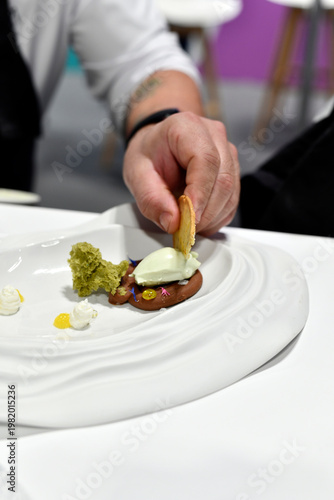 chef elaborando un postre con helado, pistacho, y torta crujiente