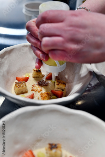 chef elaborando postre de fresas y pan crujiente con crema