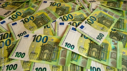 Pile of one hundred euro banknotes on wooden table. Cash background representing wealth, success and financial profit, 4k