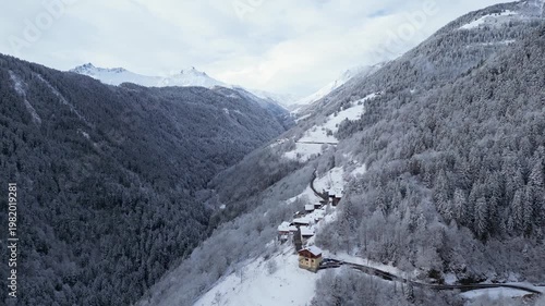 Snow covered alpine village in Tarentaise Valley with traditional houses and mountain scenery in the French Alps, Savoie, France.