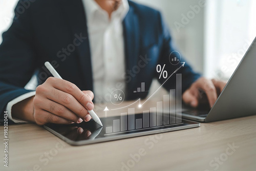 Businessman analyzing financial data on tablet with laptop