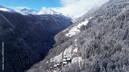 Snow covered alpine village in Tarentaise Valley with traditional houses and mountain scenery in the French Alps, Savoie, France.