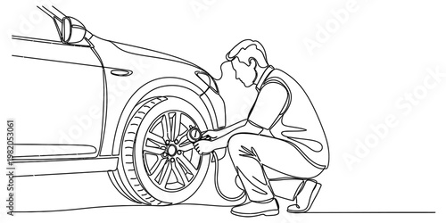 A man crouching down to check the air pressure in the tire of his car using a handheld gauge tool.