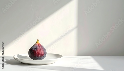 Single ripe fig on a white plate against a light wall, bathed in sunlight and casting soft shadows