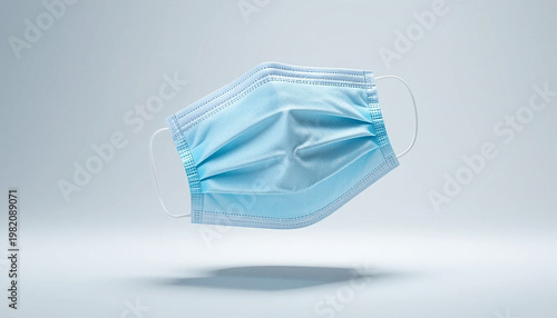 floating blue surgical face mask on gray background