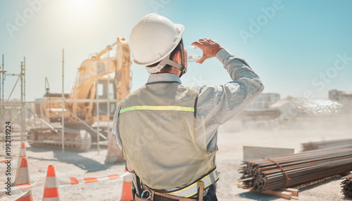 炎天下の建設現場で水分補給をする作業員の後ろ姿（熱中症対策）