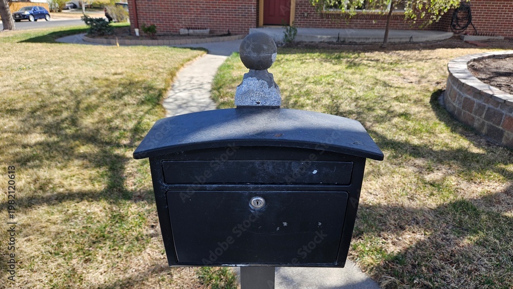 Obraz premium a plan black mailbox in front of a brick house