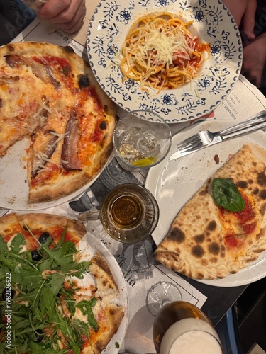 Italian dinner table with pizza pasta and calzone