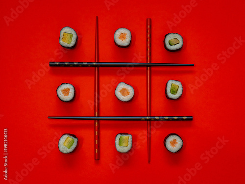 Das Spiel Tic Tac Toe mit Maki-Sushi vor rotem Hintergrund