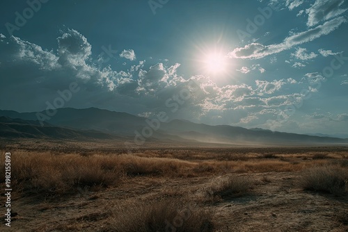 Sunlight Breaking Through Clouds Over Arid Landscape.