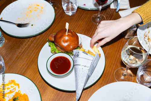 Diner meal with burger, fries and wine on wooden table