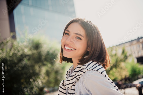 Fotografia Smiling young woman portrait outdoors in city enjoying a sunny day, casual style