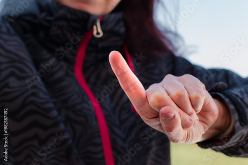 Woman making gesture with her hand outdoors