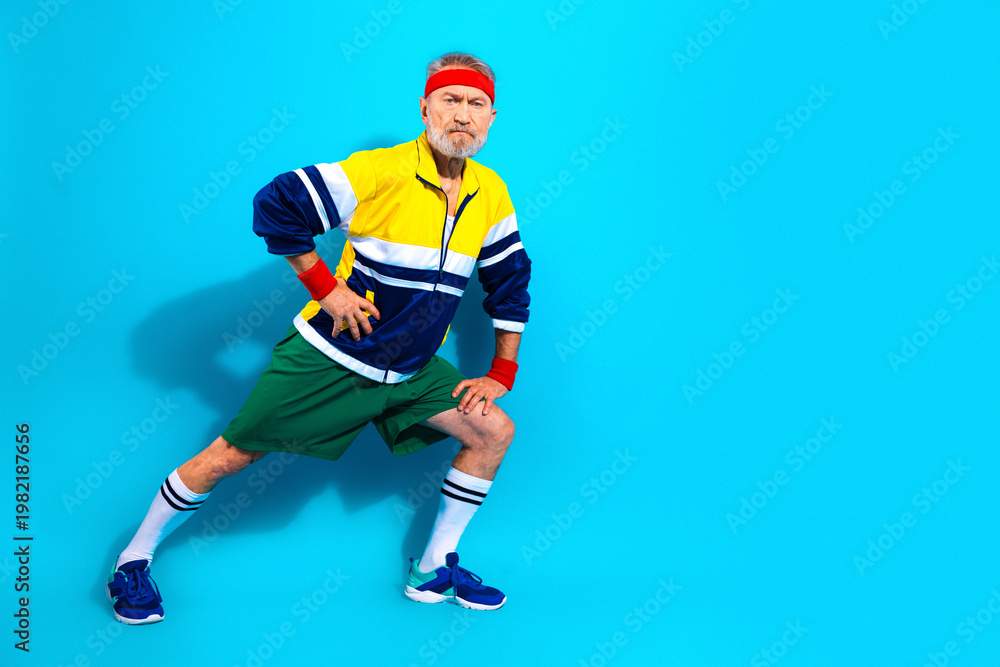 Obraz premium Active senior man stretching in retro sportswear and headband for fitness and workout concept
