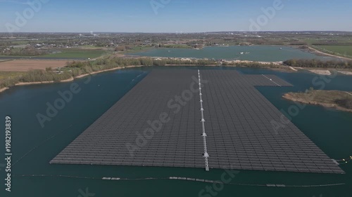 Wide aerial orbit of floating solar farm and lake landscape