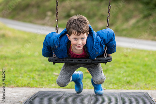 Child swings joyfully in park on a sunny day