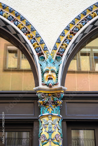 Colorful carved medieval column with green face in Zurich