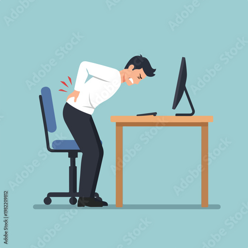 An office worker clutching his lower back in pain while standing from his desk