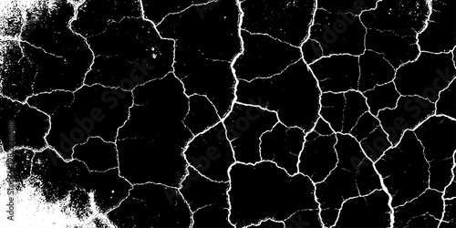  grunge texture of a cracked, weathered concrete wall in black and white monochrome. surface features intricate fracture patterns spreading organically across aged plaster.