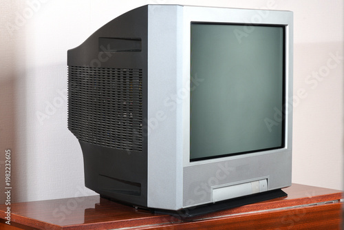 Photos An old silver CRT TV with against a wallpaper background.