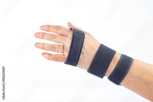 Female hand wearing orthopedic wrist brace isolated on white background. Medical support device for stabilization, rehabilitation, injury treatment and physiotherapy concept. View from top.