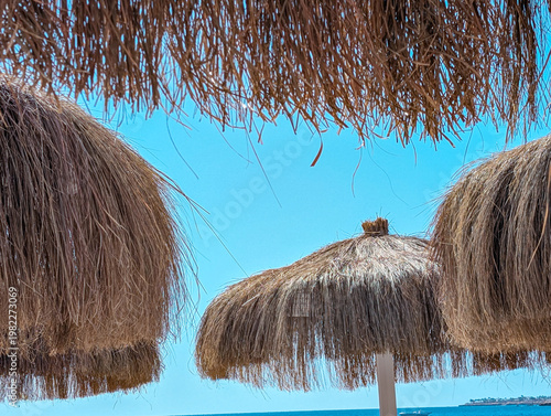 Thatched parasols under blue sky